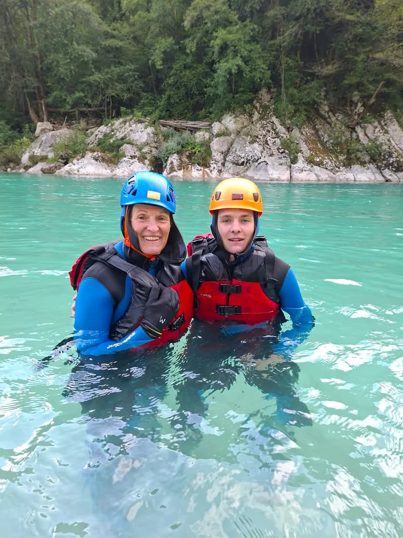 Two guests smiling in the emerald water